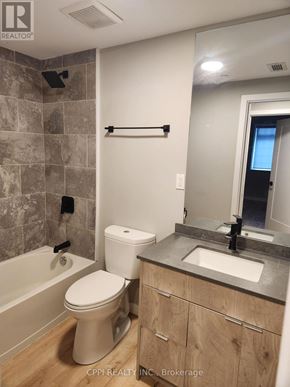 Oshawa (O'neill) condo for rent - A bathroom with a toilet, sink, and tub.