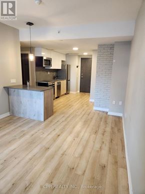 Oshawa (O'neill) condo for rent - A kitchen with a wooden floor and a white wall.