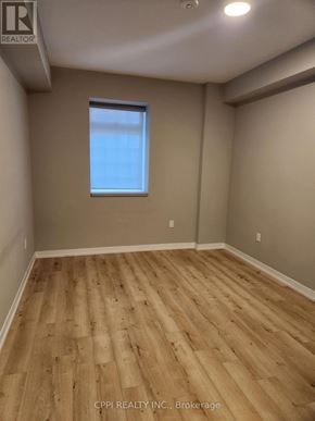 Oshawa (O'neill) condo for rent - A room with wooden flooring and a window.