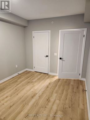 Oshawa (O'neill) condo for rent - A room with two white doors and wooden flooring.