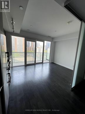Toronto (Church-Yonge Corridor) condo for rent - A room with a dark floor and white walls, with a glass door leading to a balcony.