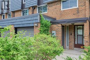 Toronto (Hillcrest Village) townhouse for rent - A house with a grey garage door and a brick wall.