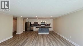 London condo for rent - A spacious living room with a kitchen in the background.