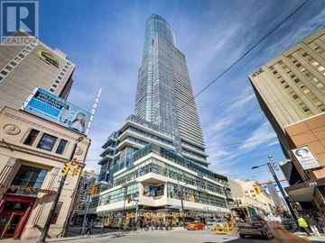 Toronto (Bay Street Corridor) condo for rent - A tall glass building is under construction in the middle of a city street.