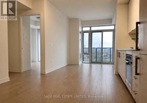 Toronto (Waterfront Communities) condo for rent - A spacious living room with a kitchen area in the background.