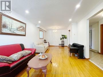 Toronto (L'amoreaux) apartment for rent - A living room with a red couch, a coffee table, and a painting on the wall.