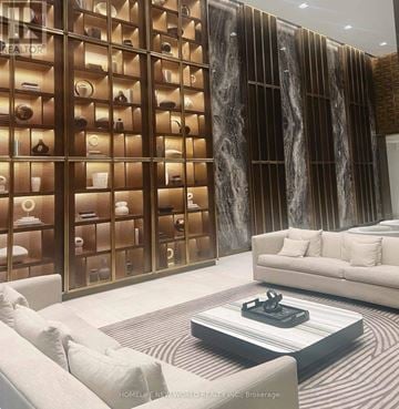 Toronto (Mount Pleasant West) condo for rent - A modern living room with a glass display cabinet filled with jewelry and a white sofa.