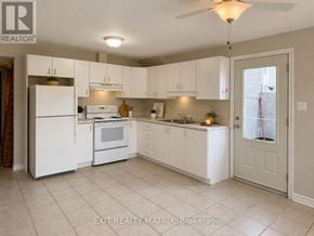 Casselman multi-family for rent - A kitchen with white appliances and cabinets.