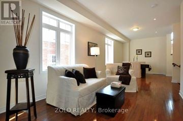 Newmarket (Stonehaven-Wyndham) house for rent - A living room with a white couch and a black table.