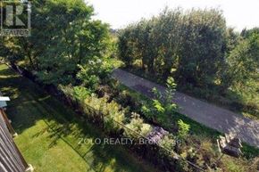 Newmarket (Stonehaven-Wyndham) house for rent - A bird's eye view of a lush green landscape with a pathway and a building on the left.