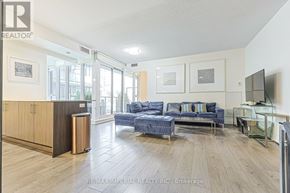 Toronto (Kensington-Chinatown) condo for rent - A spacious living room with a blue couch and a television.