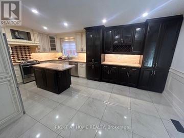 Vaughan (West Woodbridge) apartment for rent - A kitchen with black cabinets and a marble floor.