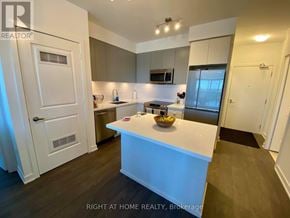 Mississauga (Central Erin Mills) condo for rent - A modern kitchen with a white island and wooden floors.