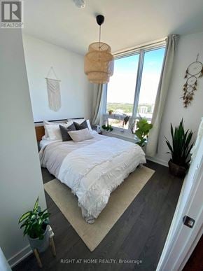 Mississauga (Central Erin Mills) condo for rent - A bedroom with a large bed and a view of the city.