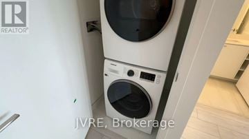Brampton (Fletcher's Creek South) condo for rent - A white washing machine with a black door is in a kitchen.