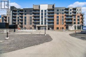 Ottawa condo for rent - A large apartment complex with a gravel lot in front.