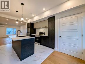 Dieppe apartment for rent - A modern kitchen with a large island and wooden floors.