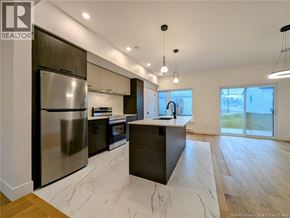 Dieppe apartment for rent - A modern kitchen with a large island and stainless steel appliances.