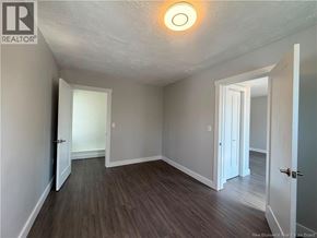 Moncton apartment for rent - A room with a wooden floor and white walls.