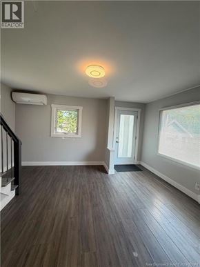 Moncton apartment for rent - A room with a wooden floor and a window with blinds.