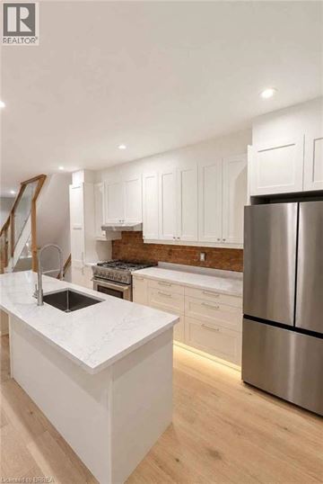 Hamilton apartment for rent - A modern kitchen with white cabinets and a stainless steel refrigerator.