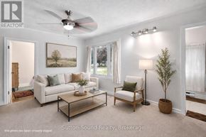 Owen Sound apartment for rent - A living room with a white couch, a coffee table, and a ceiling fan.