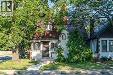 Hamilton apartment for rent - A house with a brown door is surrounded by greenery.