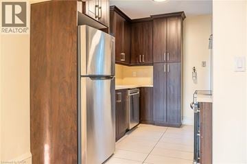 Hamilton apartment for rent - A modern kitchen with a stainless steel refrigerator and wooden cabinets.