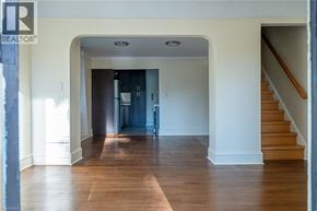 Hamilton apartment for rent - A spacious hallway with a staircase on the right and a doorway leading to another room on the left.