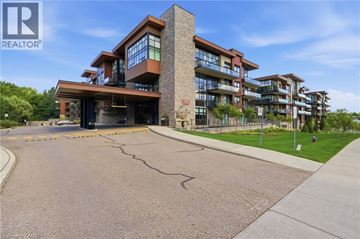 Mississauga condo for rent - A modern apartment building with a parking lot in front.
