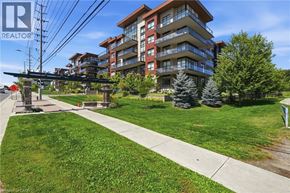 Mississauga condo for rent - A large apartment complex with a grassy area in front.
