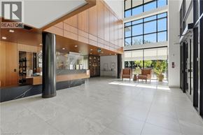 Mississauga condo for rent - A spacious lobby with a reception desk and a large window.