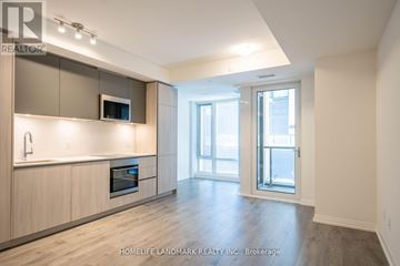 Toronto (Waterfront Communities) condo for rent - A spacious kitchen with wooden cabinets and a microwave built into the cabinetry.