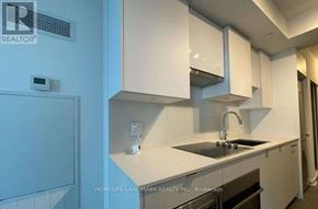 Toronto (Mount Pleasant West) condo for rent - A kitchen with white cabinets and a black countertop.