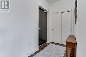 Barrie (Holly) condo for rent - A room with a black door and a white door, a rug, and a wooden table.