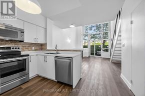 Toronto (Mimico) condo for rent - A modern kitchen with stainless steel appliances and white cabinetry.