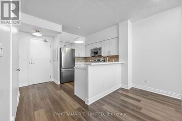 Toronto (Mimico) condo for rent - A kitchen with white cabinets and a wooden floor.