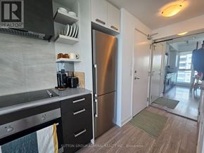 Toronto (High Park North) condo for rent - A kitchen with a stainless steel refrigerator and a stove top oven.