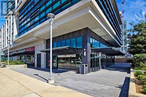 Mississauga (City Centre) condo for rent - A modern building with a glass facade and a covered walkway in front.