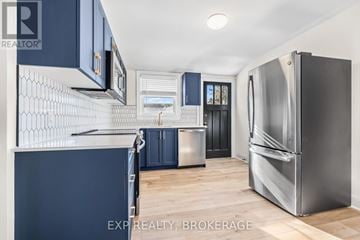 Kingston (Central City East) triplex for rent - A kitchen with dark blue cabinets and a stainless steel refrigerator.