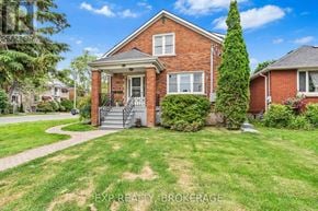 Kingston (Central City East) triplex for rent - A red brick house with a front porch and a tree in front.