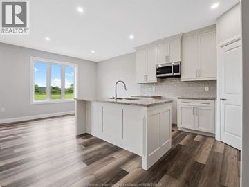 Leamington apartment for rent - A kitchen with white cabinets and a wooden floor.