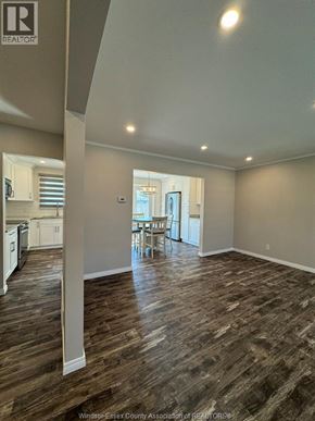 Kingsville apartment for rent - A large empty room with wood flooring and a kitchen area in the background.