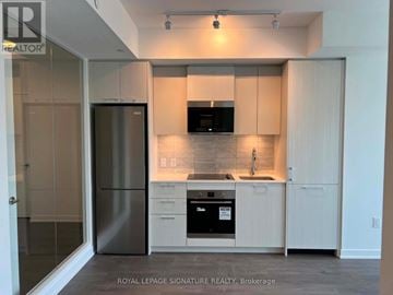 Toronto (Regent Park) condo for rent - A modern kitchen with white cabinets and stainless steel appliances.