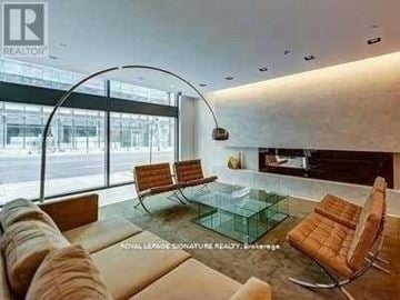 Toronto (Bay Street Corridor) condo for rent - A modern living room with a glass table and leather chairs.