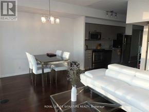 Toronto (Bay Street Corridor) condo for rent - A modern kitchen and dining area with white furniture and a glass table.