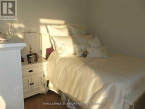 Toronto (Bay Street Corridor) condo for rent - A white bedroom with a bed, nightstand, and lamp.