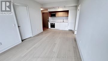 Toronto (Annex) condo for rent - A spacious room with a kitchen area in the background.
