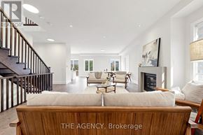 Vaughan (Patterson) apartment for rent - A spacious living room with a staircase on the left and a fireplace in the middle.
