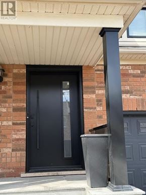 Oakville (Wm Westmount) townhouse for rent - A black door with a glass window is set in a brick wall.